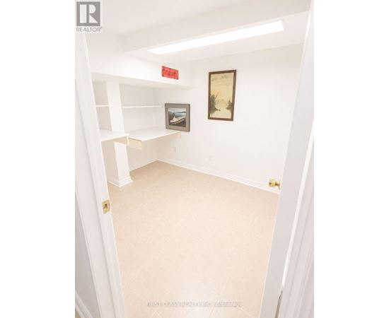 A white hallway with a painting on the wall.