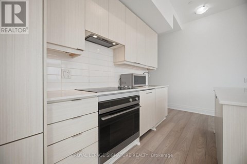 A kitchen with white cabinets and a black oven.