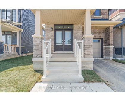 A house with a front porch and a sign that says "TEN REALTY INC. Brokerage".