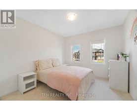A bedroom with a bed, nightstand, and window.