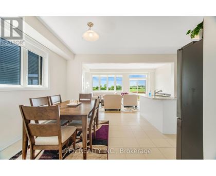 A dining room with a table set for six with a view of the backyard.