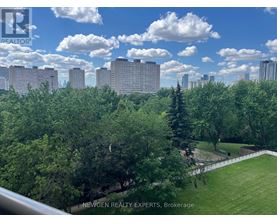 A cityscape with buildings and trees in the foreground.