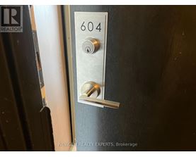 A door handle with the number 604 on it.