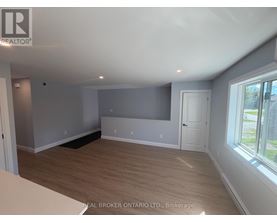 A room with a grey wall and wooden flooring.