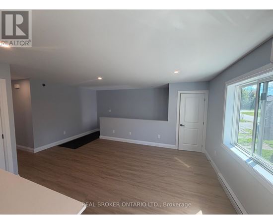 A room with a grey wall and wooden flooring.
