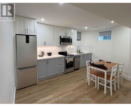 A kitchen with white cabinets and a wooden table.