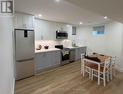 A kitchen with white cabinets and a wooden table.