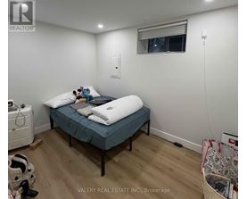 A bedroom with a bed, a window, and a wall-mounted air conditioner unit.