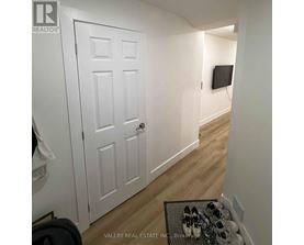A hallway with a white door and a pair of shoes on a table.