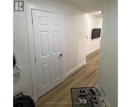 A hallway with a white door and a pair of shoes on a table.