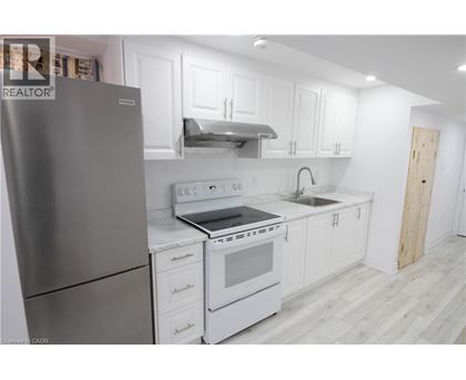 A modern kitchen with white cabinets and a stainless steel refrigerator.