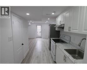 A kitchen with white cabinets and a black refrigerator.