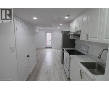 A kitchen with white cabinets and a black refrigerator.