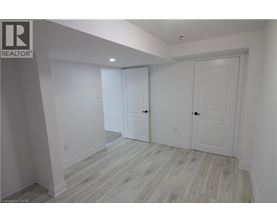A white room with wood flooring and two doors.