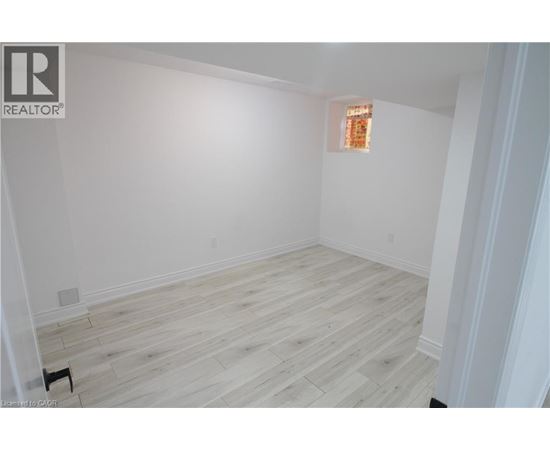 A room with wooden flooring and white walls.