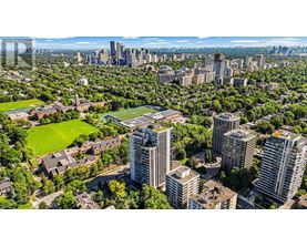 A cityscape with a mix of residential and commercial buildings, surrounded by lush greenery.