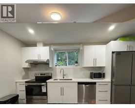 A white kitchen with a black stove top oven.