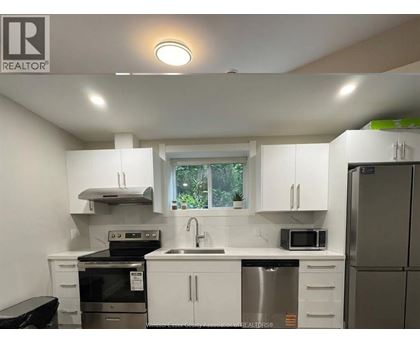 A white kitchen with a black stove top oven.
