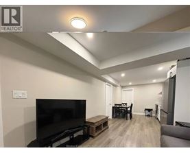 A living room with a television, a dining table, and a couch.