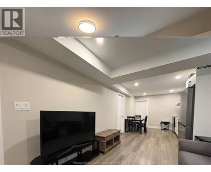 A living room with a television, a dining table, and a couch.