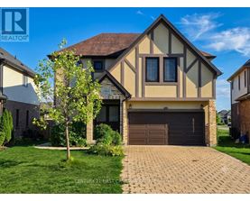 A house with a garage and a tree in front of it.