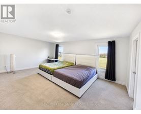 A bedroom with a large bed and a window with black curtains.
