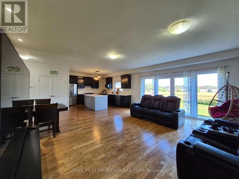 A living room with a black couch and a wooden floor.