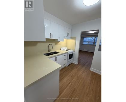 A kitchen with white cabinets and a sink.