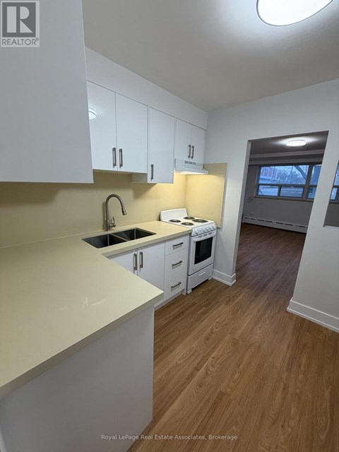 A kitchen with white cabinets and a sink.