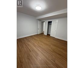 A room with wooden flooring and white walls.