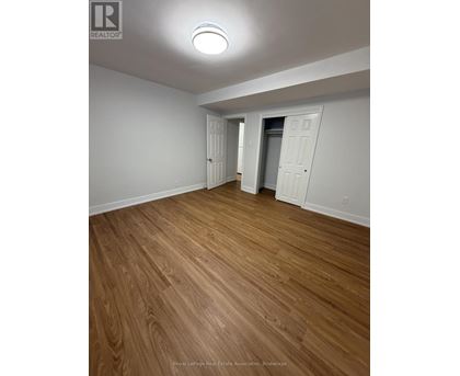 A room with wooden flooring and white walls.