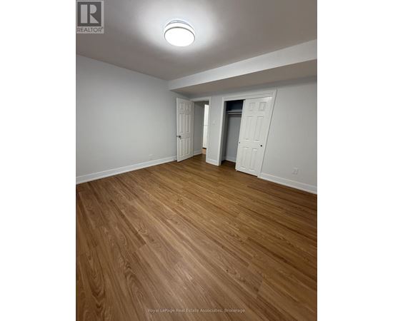 A room with wooden flooring and white walls.