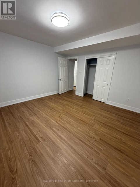 A room with wooden flooring and white walls.