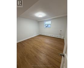 A room with wooden flooring and a window.