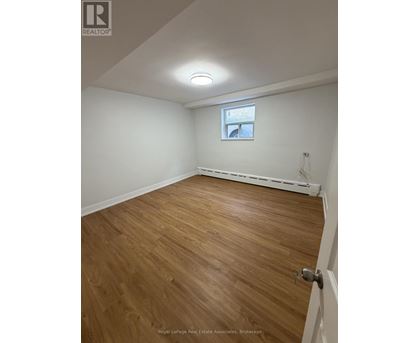A room with wooden flooring and a window.