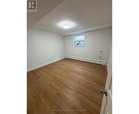 A room with wooden flooring and a window.