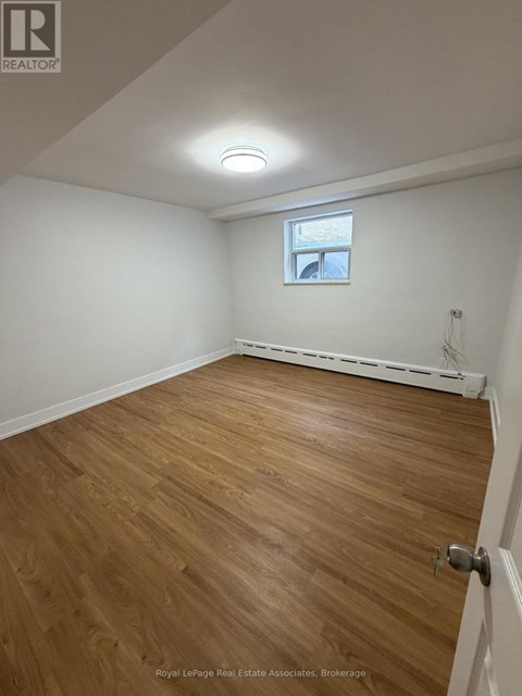 A room with wooden flooring and a window.