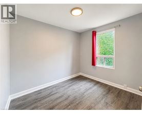 A room with a window and a red curtain.