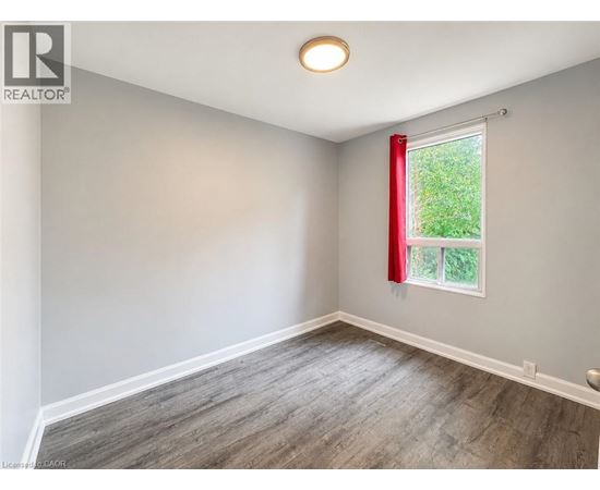 A room with a window and a red curtain.