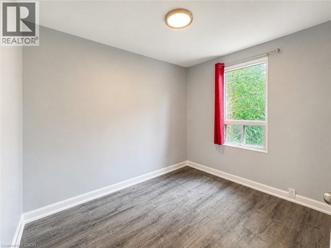 A room with a window and a red curtain.