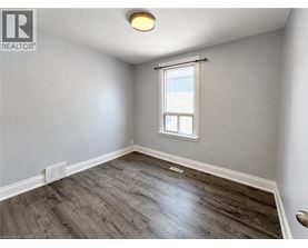 A room with a window and a wooden floor.