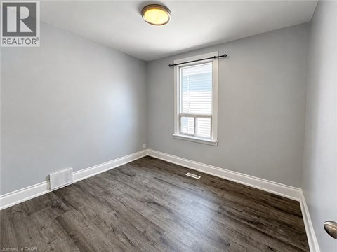 A room with a window and a wooden floor.