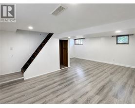 A spacious room with a staircase and a window.