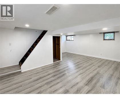 A spacious room with a staircase and a window.