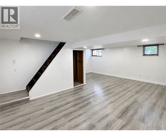A spacious room with a staircase and a window.