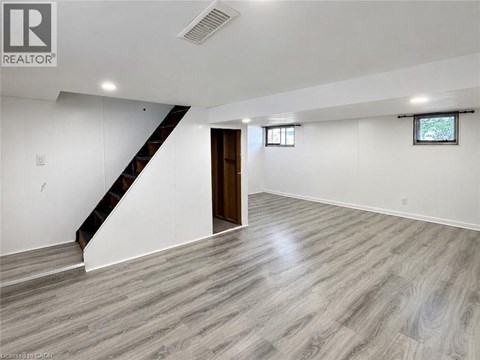 A spacious room with a staircase and a window.