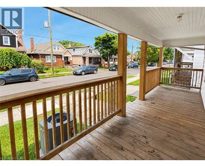 A wooden deck with a railing and a trash can on it.