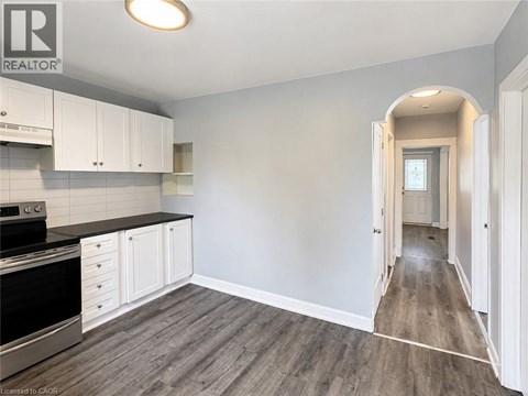 A kitchen with white cabinets and a black stove top oven.