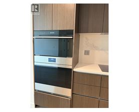 A modern kitchen with a stainless steel oven and wooden cabinets.