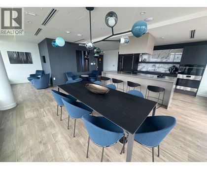 A modern dining room with a long table and blue chairs.